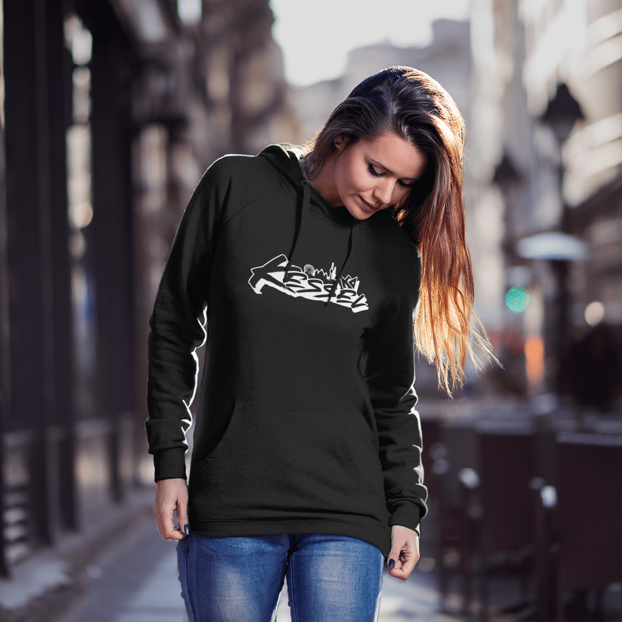 a woman in a black hoodie is walking down the street